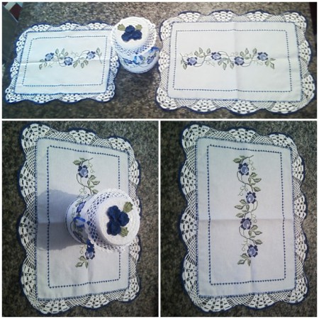 Conjunto de Caminho de Mesa Floral: bordado em ponto cruz com tons de azul e verde, todo contornado e finalizado com crochê, detalhe para o bico branco em formato de flor. Pote Floral: coberto com tecido e bordado em ponto cruz, finalizado com 3 flores 